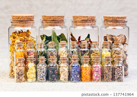 Healing herbs and tinctures in bottles on sackcloth, dried flowe Healing herbs and tinctures in bottles on sackcloth, dried flowe 137741964