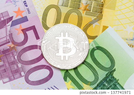 Silver Bitcoin close-up. Euro currency as a background. Macro ph Silver Bitcoin close-up. Euro currency as a background. Macro ph 137741971