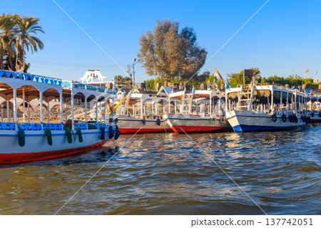 Tourist boats moored near the shore of Nile river in Luxor, Egypt Tourist boats moored near the shore of Nile river in Luxor, Egypt 137742051