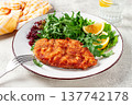 Milanese chicken, Crispy breaded chicken served, with fresh herbs, and lemon wedges, 137742178
