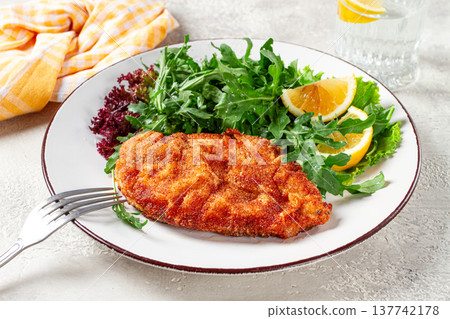 Milanese chicken, Crispy breaded chicken served, with fresh herbs, and lemon wedges, Milanese chicken, Crispy breaded chicken served, with fresh herbs, and lemon wedges, 137742178