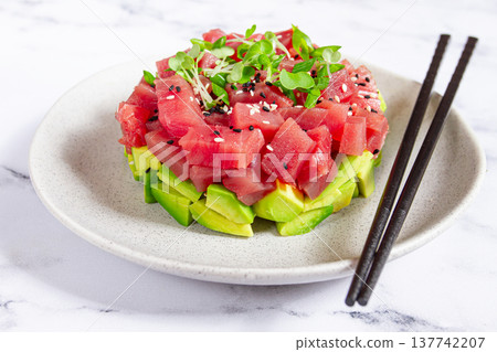 Fresh tuna tartare with avocado served on a marble table with soy sauce and seaweed salad Fresh tuna tartare with avocado served on a marble table with soy sauce and seaweed salad 137742207