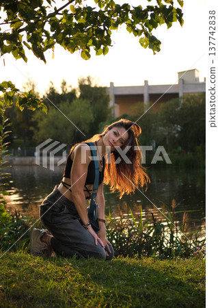 woman kneels by a lakeside, her hair flowing freely in the golden sunset, embodying strength and vulnerability. This moment captures the essence of individuality and the quiet power of authenticity. woman kneels by a lakeside, her hair flowing freely in the golden sunset, embodying strength and vulnerability. This moment captures the essence of individuality and the quiet power of authenticity. 137742838
