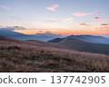 Majestic mountain sunrise with pink and purple sky and layered hills. 137742905