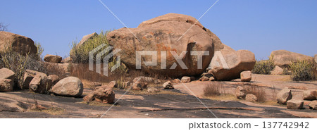 Round boulder laying on top of a cube shaped granite boulder, Hampi Hippie Island, India. Round boulder laying on top of a cube shaped granite boulder, Hampi Hippie Island, India. 137742942