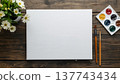 A blank white canvas on a rustic wooden table, with watercolors, flowers, and Easter decor. Concept art, education, DIY creativity, Easter decor. 137743434