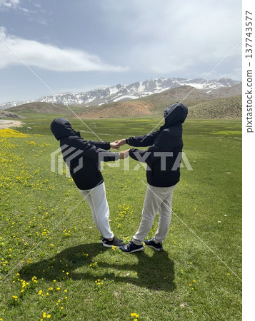 Hikers embracing landscape. Mountains chairs relaxation. mountains in spring silhouette of a tourist Hikers embracing landscape. Mountains chairs relaxation. mountains in spring silhouette of a tourist 137743577