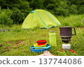 Colorful collapsible silicone camping tableware set on tent background. 137744086