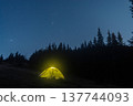 Illuminated camping tent under a starry night sky in the mountains. 137744093