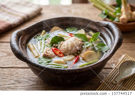 Thai herbal chicken broth in rustic bowl with steam 137744517