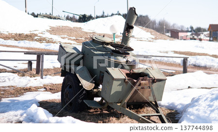 Decommissioned Tank Turret In Snow, Rural Roadside Relic By Frozen Field Rusted Armor Plates, Broken Optics, Trailer Hitch And Scattered Metal Parts Suggest Postconflict Abandonment Muted 137744898