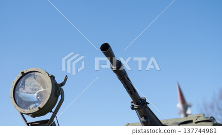 Spotlight And Gun Barrel Against Clear Sky, Closeup Of Armored Vehicle Exterior Showing Metal Texture, Rivets And Tactical Lighting, Calm Atmosphere With Precise Mechanical Detail 137744981