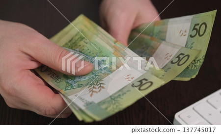 Close Examination Of Currency Notes. Hands Inspecting Banknotes Symbolizing Financial Decisions. Intimate Shot Of Hands Reviewing Cash As Representation Of Economic Planning 137745017