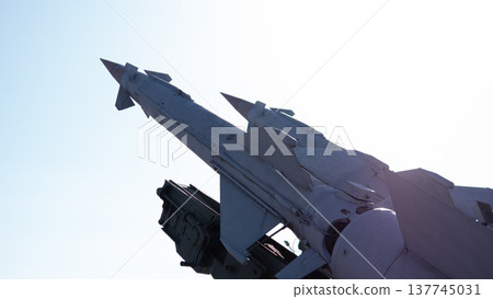 Missile Launcher Silhouetted Against Sky, Sun Flare Casting Dramatic Shadow Over Aged Metal Surface, Static Display Evoking Cold War History, Suggested Role Of Technician Conducting Visual 137745031