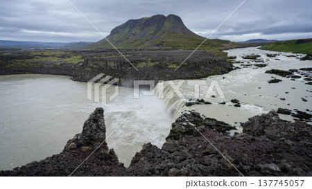 Huge cascade waterfall with big mountain in background, Iceland 137745057