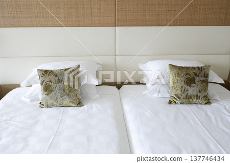 A clean and tidy hotel room with twin beds and cushions. A clean and tidy hotel room with twin beds and cushions. 137746434