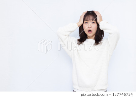 Surprised woman holding her head 137746734