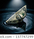 A fragile origami boat folded from a US dollar bill floats on dark rippling water under dramatic lighting. Concept of economic risk. High quality photo 137747299