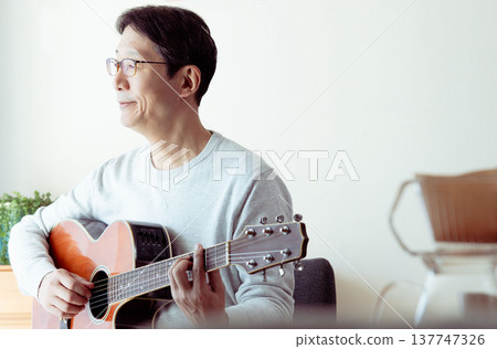 Hands of a middle-aged man playing the guitar Hands of a middle-aged man playing the guitar 137747326