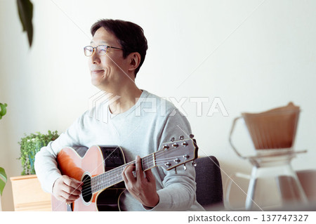 一位中年男子彈吉他的手 137747327