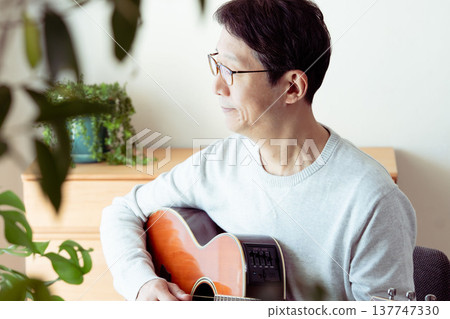 一位中年男子彈吉他的手 137747330
