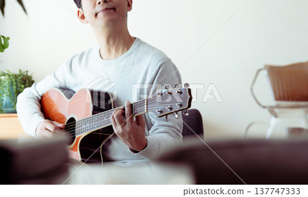 一位中年男子彈吉他的手 137747333
