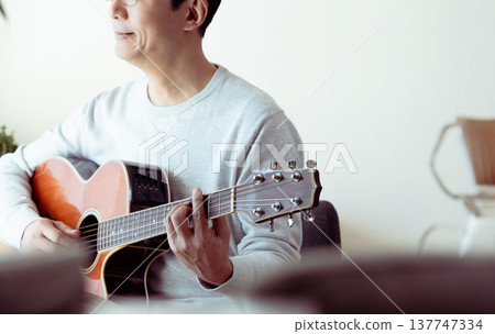 一位中年男子彈吉他的手 137747334