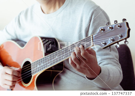 Hands of a middle-aged man playing the guitar 137747337