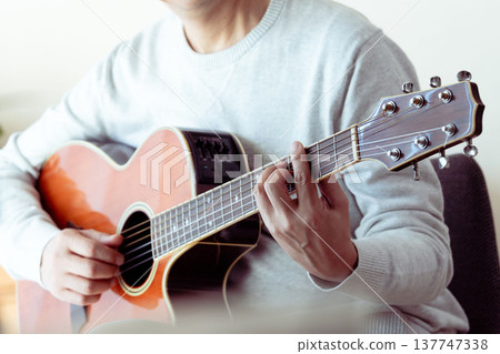 Hands of a middle-aged man playing the guitar 137747338