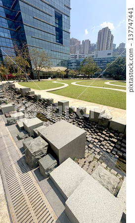 Modern architectural design with a water feature and manicured lawn in a city park Modern architectural design with a water feature and manicured lawn in a city park 137747441