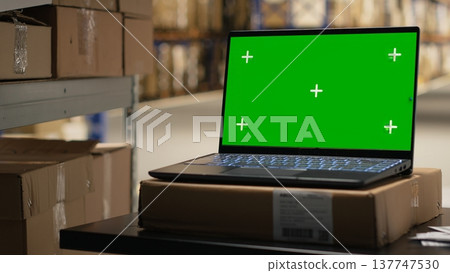 Empty logistics hub stock room with isolated screen on laptop, large business retail operations in industrial space with racks and shelves for goods storage. Fulfillment center e-commerce. 137747530