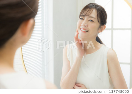 Woman applying makeup in the mirror Woman applying makeup in the mirror 137748000