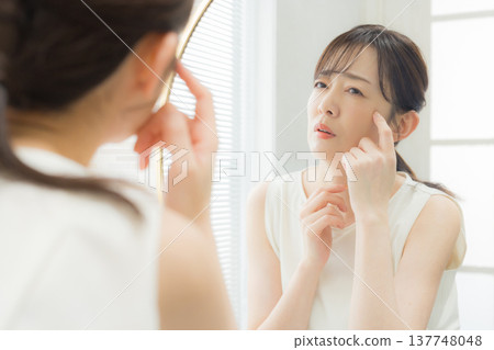 A woman troubled watching a mirror 137748048