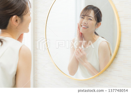 一個女人看著鏡子困擾著 一個女人看著鏡子困擾著 137748054