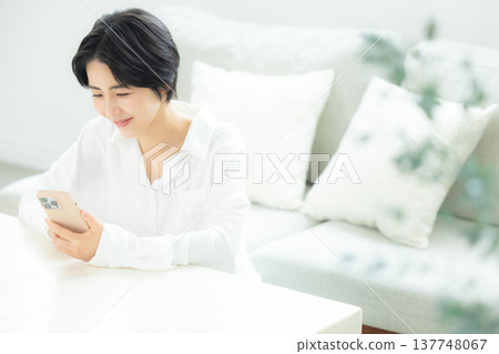 A woman watching a smartphone A woman watching a smartphone 137748067