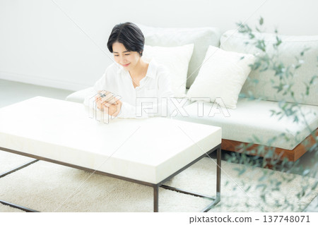 A woman watching a smartphone A woman watching a smartphone 137748071