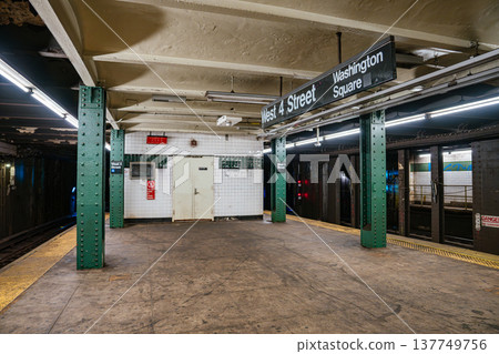 Empty New York City subway platform at West 4 Street Washington Square station in Manhattan. Underground metro station interior with green steel columns, tiled walls, and railway tracks. Empty New York City subway platform at West 4 Street Washington Square station in Manhattan. Underground metro station interior with green steel columns, tiled walls, and railway tracks. 137749756