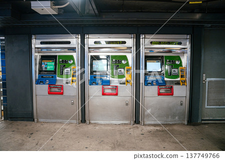 MetroCard vending machines line the wall inside a New York City subway station. The automated machines provide tickets and fare payment for public transportation. MetroCard vending machines line the wall inside a New York City subway station. The automated machines provide tickets and fare payment for public transportation. 137749766
