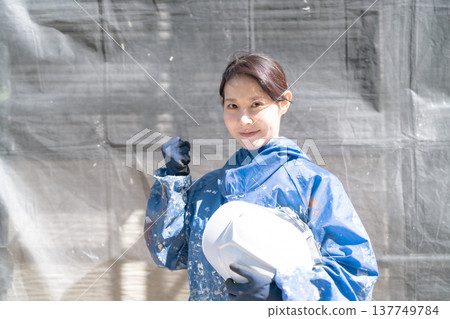 一位女工匠在建築業中做出勝利的姿態。 一位女工匠在建築業中做出勝利的姿態。 137749784