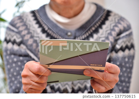 Seniors checking their savings passbook Seniors checking their savings passbook 137750615