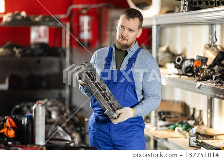 Man professional auto mechanic repairing car engine in garage Man professional auto mechanic repairing car engine in garage 137751014