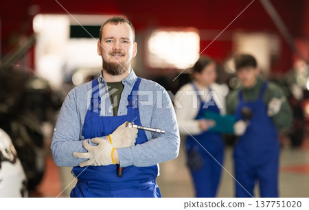 Smiling car service employee with tools 137751020