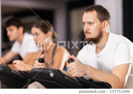 Man is exercising on an exercise bike Man is exercising on an exercise bike 137751040