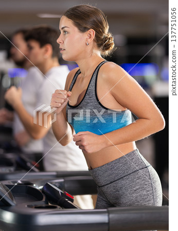 Woman running on a treadmill 137751056