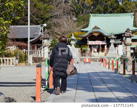 A middle-aged woman visiting Shiroyama Hachimangu Shrine in Nagoya City on a winter afternoon. A middle-aged woman visiting Shiroyama Hachimangu Shrine in Nagoya City on a winter afternoon. 137751145