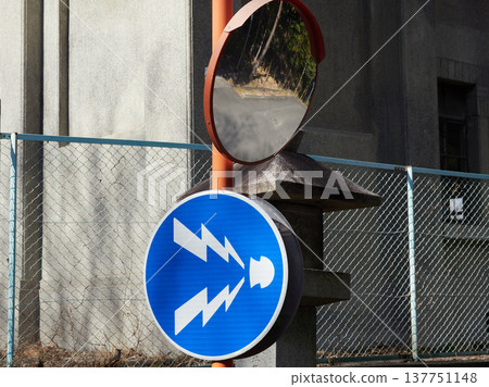 A reflective mirror and a horn honking symbol installed on a street corner in Japan. 137751148