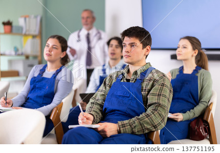 male workers listening to a medical lecture in front of a doctor 137751195