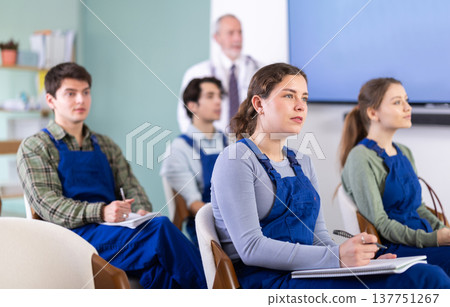Young students in blue overalls listening to a lecture on medicine Young students in blue overalls listening to a lecture on medicine 137751267