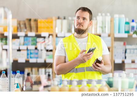 Male builder scans code on cough syrup to check expiration date Male builder scans code on cough syrup to check expiration date 137751295