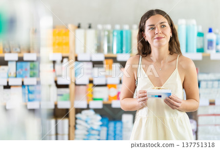 Woman choosing a cooling ointment at the pharmacy Woman choosing a cooling ointment at the pharmacy 137751318